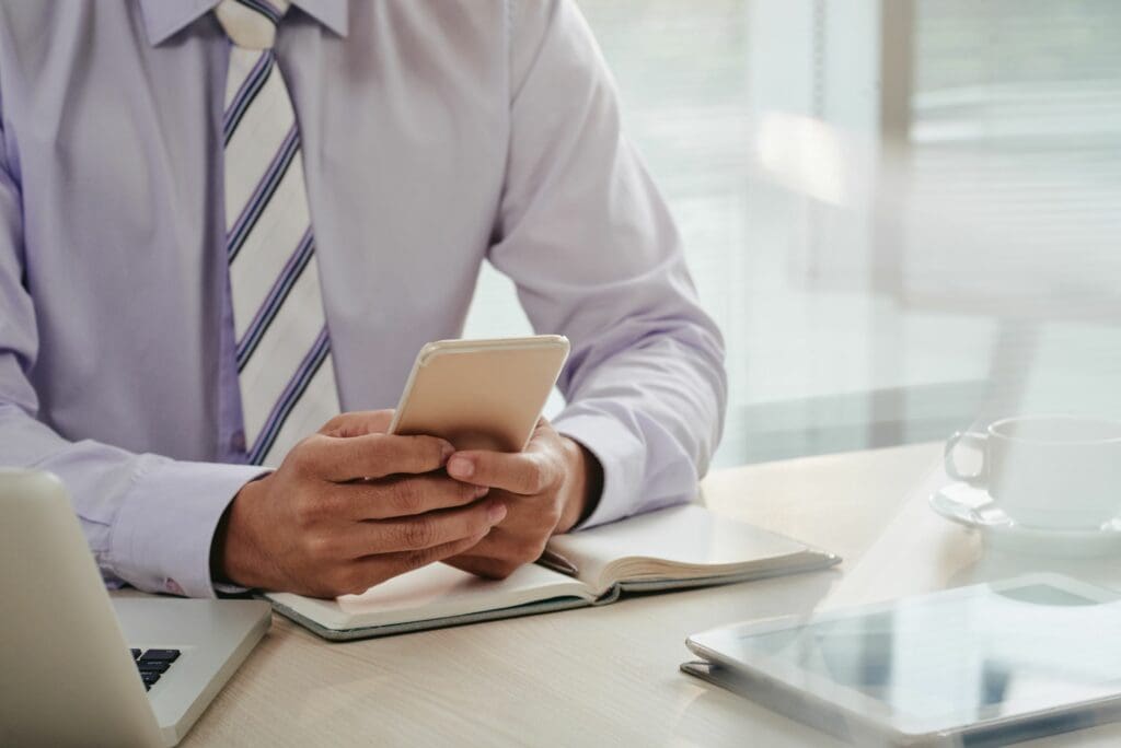 mid-section-man-checking-emails-smartphone